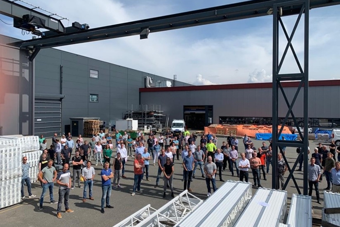 Van Der Hoeven team standing together outside the company building in an industrial yard on a sunny day.